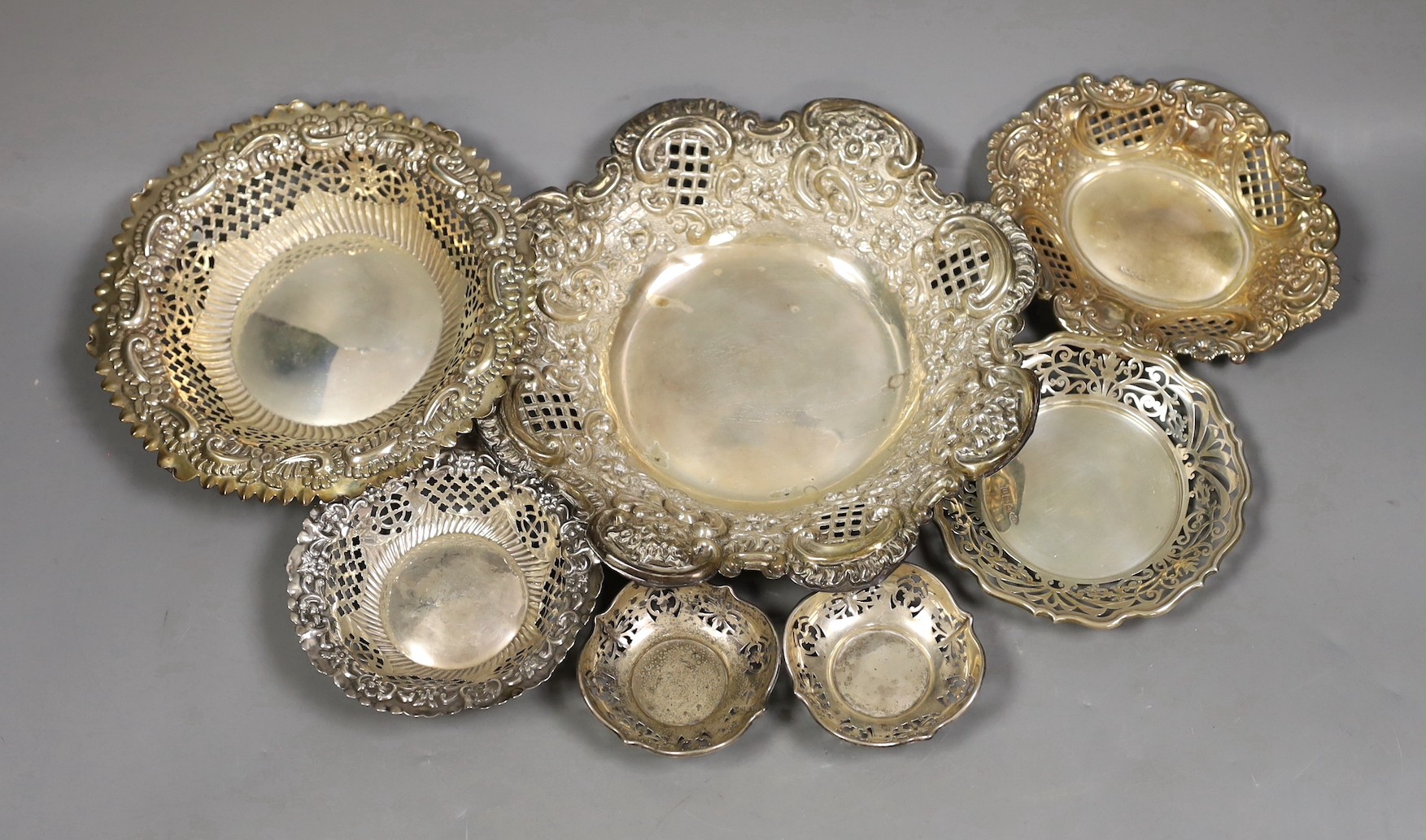 Seven assorted Victorian and later pierced silver nut or bonbon dishes, largest 22.6cm in diameter, 19.4oz.